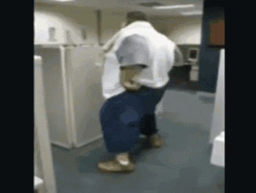 a man in a white shirt and blue pants is dancing in a hallway