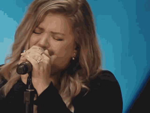 a woman singing into a microphone with the words imma whole lotta woman written below her