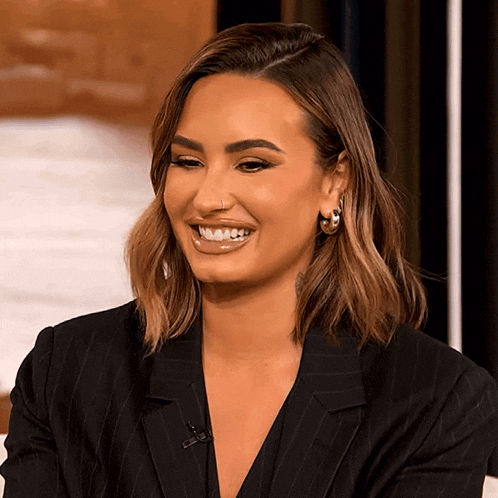 a woman with hoop earrings and a nose ring is smiling