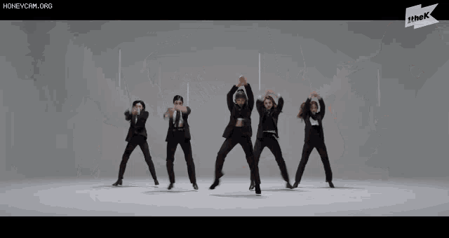 a group of people in suits and ties are dancing in a row .