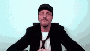 a man wearing a hat and glasses is smiling
