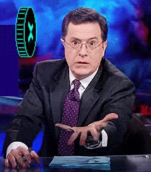 a man in a suit and tie is sitting at a table with his hands out