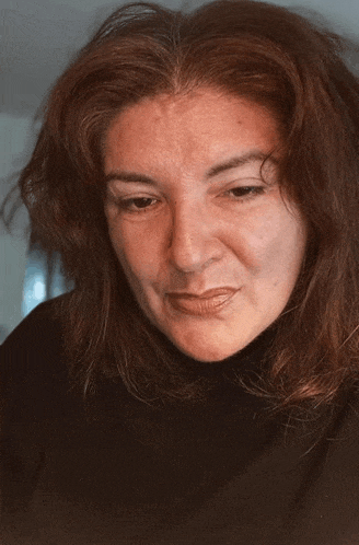 a woman with red hair looks down at something