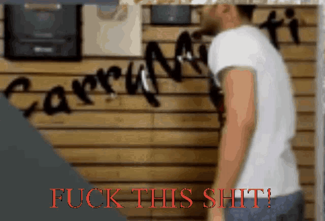 a man is standing in front of a wall that says carhartt