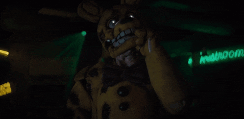 a man in a teddy bear costume is standing in front of a neon sign that says " in room "