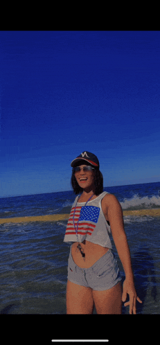 a woman wearing a hat and shorts is standing in the water