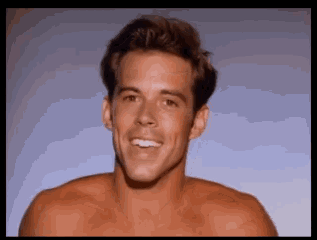 a man without a shirt is smiling for the camera