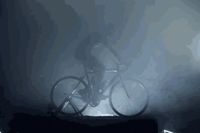 a man is riding a bike in the dark