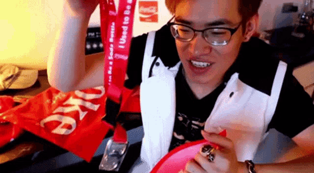 a man wearing glasses is holding a red ribbon that says i used to be