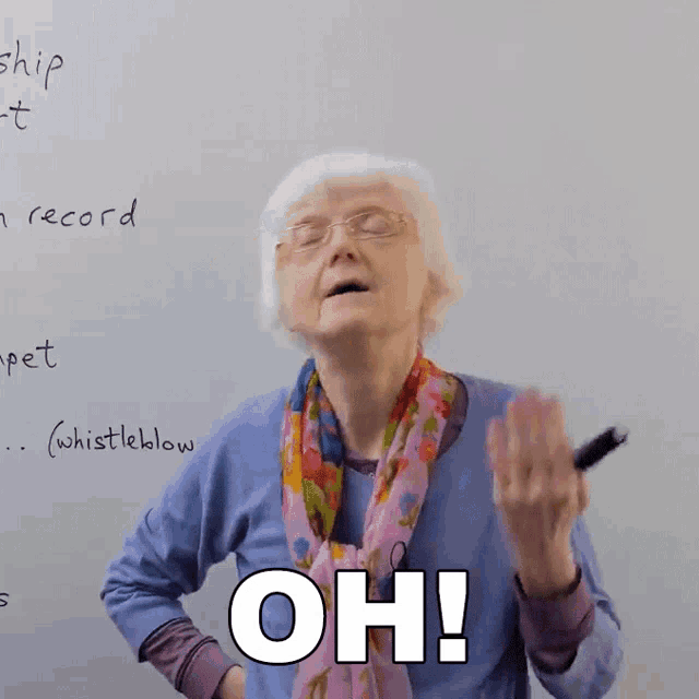 an elderly woman stands in front of a whiteboard with the word oh on it