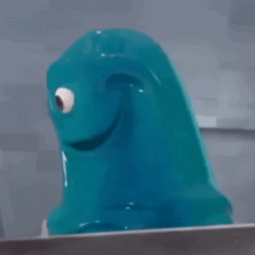 a blue monster with a big eye is sitting on a table .