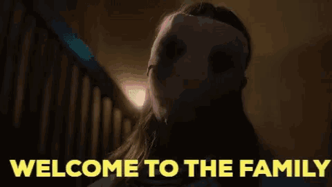 a woman wearing a mask with the words welcome to the family above her