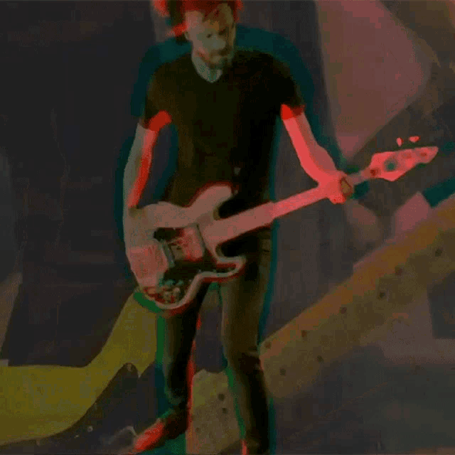 a man in a black shirt is playing a guitar in a dark room
