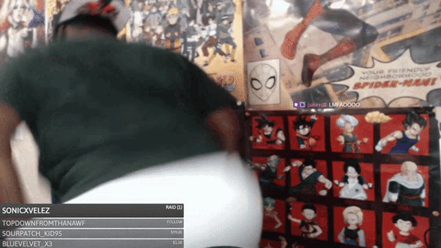 a spider-man poster hangs on a wall next to a man