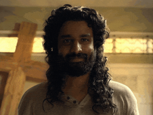 a man with long hair and a beard is smiling