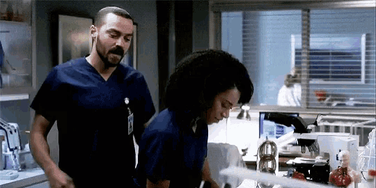 a man and woman are standing next to each other in a hospital room .