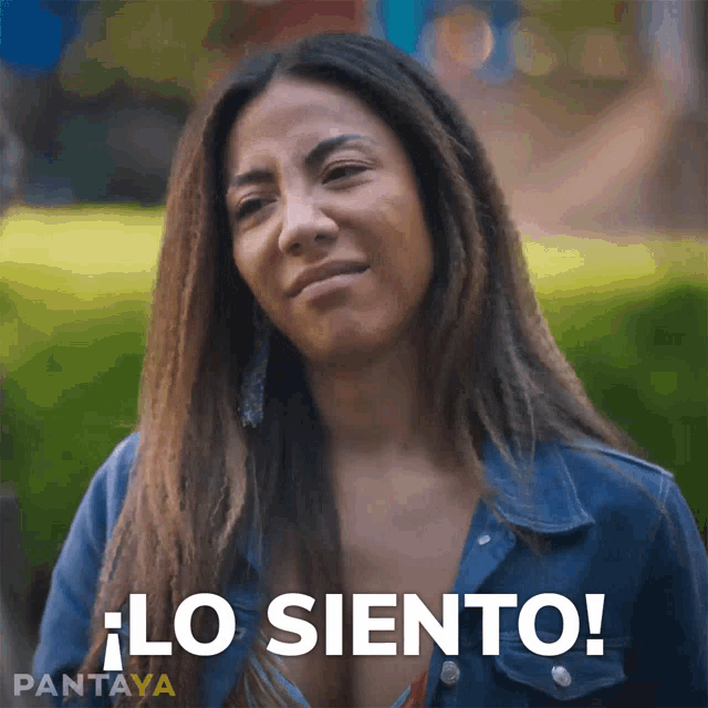 a woman in a denim jacket says " lo siento " in spanish