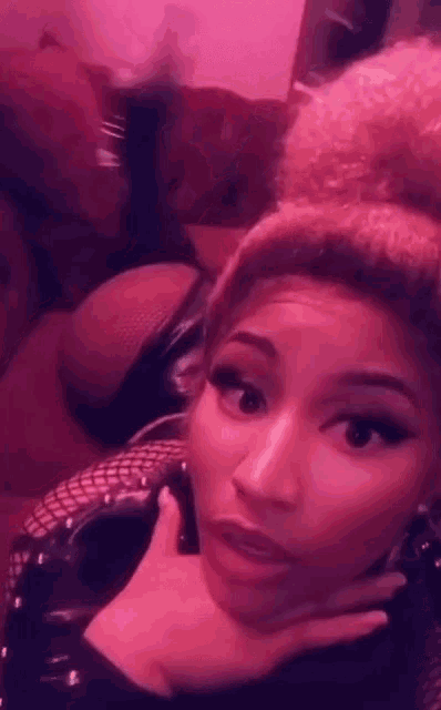 a woman laying on a couch with a pink background
