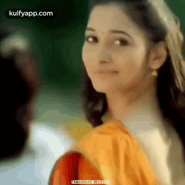 a close up of a woman 's face with a yellow shirt on .