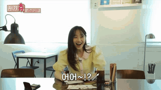a girl sitting at a table with a sign that says yes