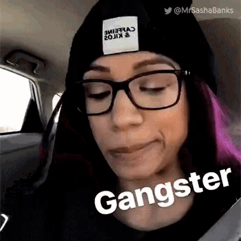 a woman wearing glasses and a beanie is sitting in a car and making a face .