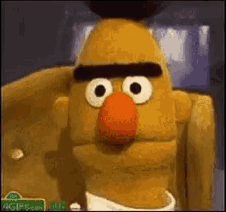 bert from sesame street is sitting in a chair