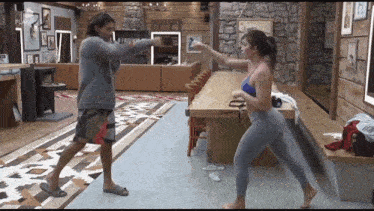a man and a woman are fighting in a room with a sign on the wall that says ' a nova '