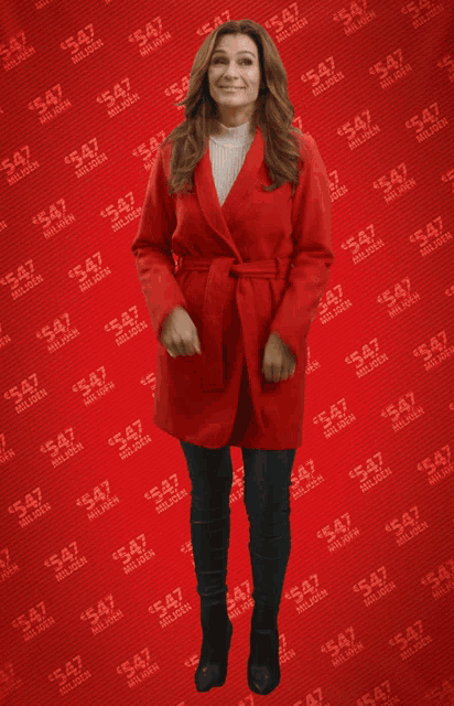 a woman in a red coat is standing in front of a red background with the number 547 on it