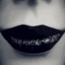 a black and white photo of a woman 's mouth with black lipstick