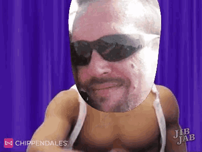 a man without a shirt is wearing sunglasses and a beard .
