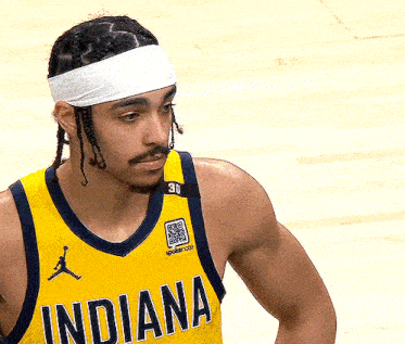 a man wearing a yellow indiana jersey and a white headband