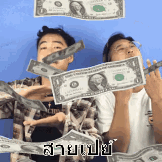 two men are throwing money in the air and one of them is wearing a shirt that says ' abercrombie & fitch ' on it