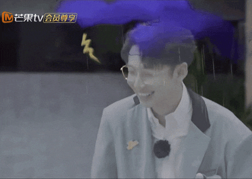 a man in a suit is smiling in front of a sign that says tv on it