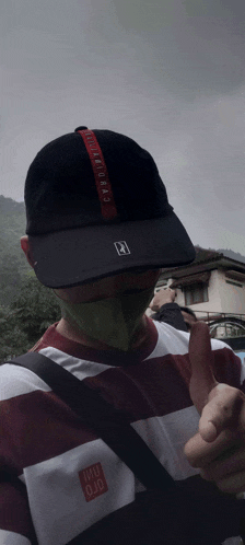a man wearing a striped shirt and a hat with the word uniqlo on it