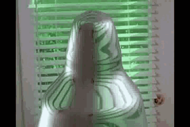 a person is wrapped in duct tape and standing in front of a window .