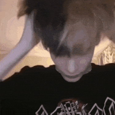 a close up of a person wearing a black shirt with a skull on it 's chest .