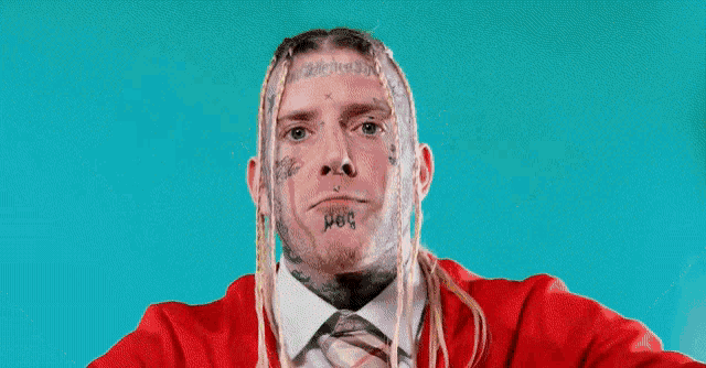a man with dreadlocks and a tattoo on his face is holding a can of soda ..