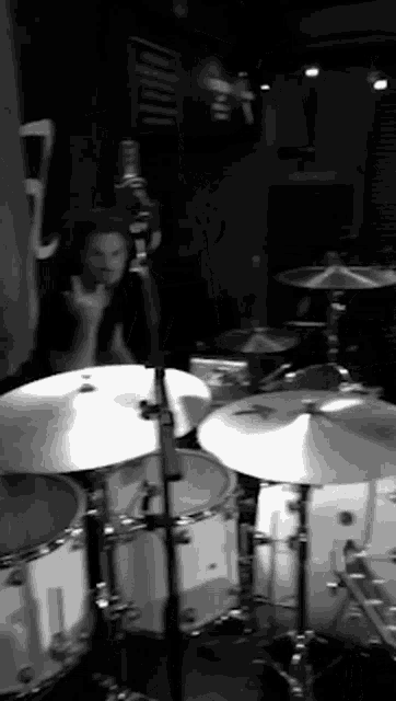 a man playing drums in a black and white photo with the number 7 in the background
