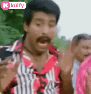a man with a mustache is making a funny face while standing in front of a crowd of people .