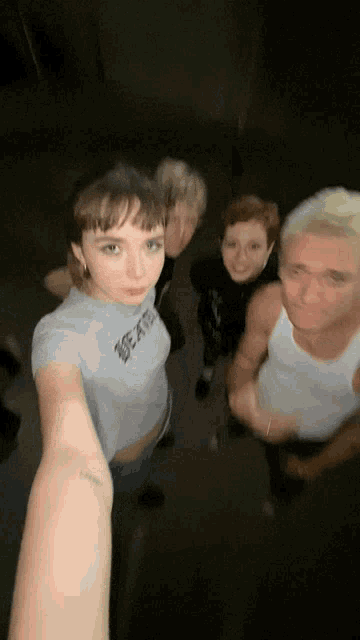 a group of people are posing for a picture and one of them has a tattoo on her wrist that says " i love you "