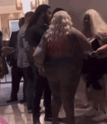 a group of people are standing in a room and one of them is wearing a shirt that says ' i love you '