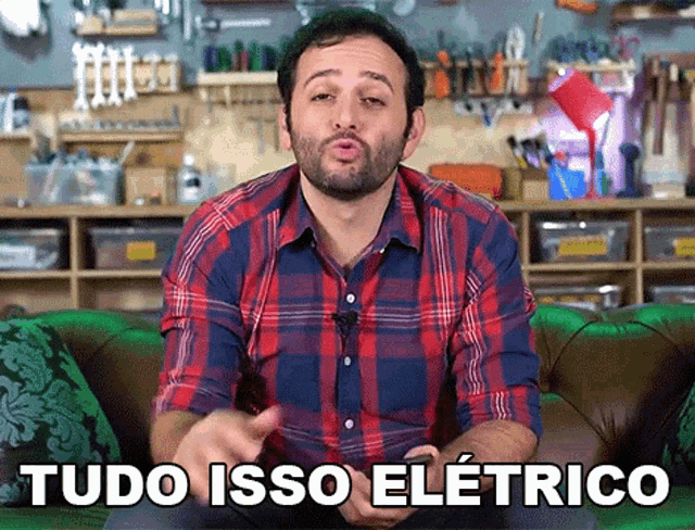 a man in a plaid shirt is sitting on a green couch with the words tudo isso eletrico above him