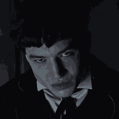a close up of a man 's face in a suit and tie .