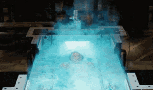 a person is laying in a bathtub with blue water