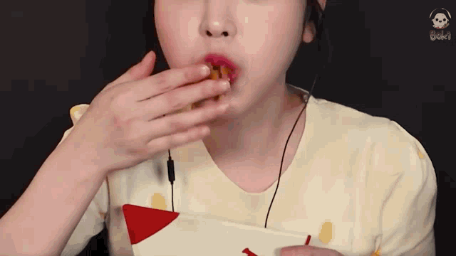 a woman is eating a piece of food from a bag with her hand .