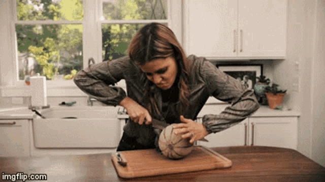 a woman is cutting a pumpkin on a cutting board with imgflip.com at the bottom of the screen