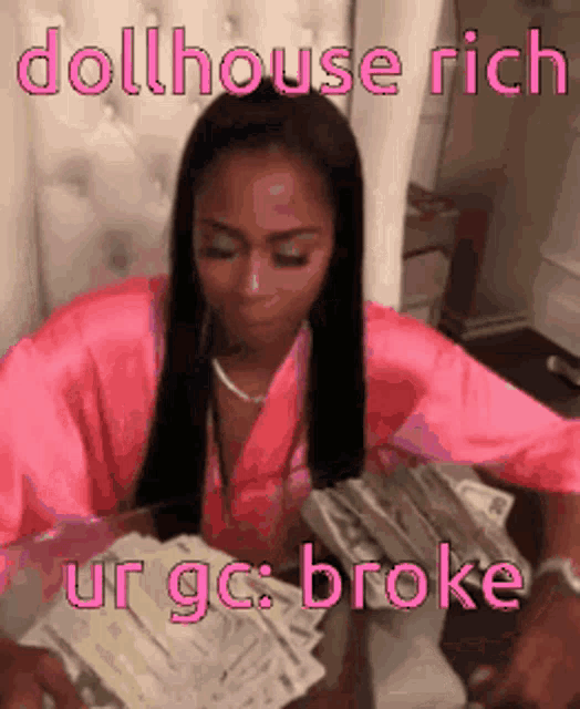 a woman in a pink robe is sitting at a table with a stack of money .