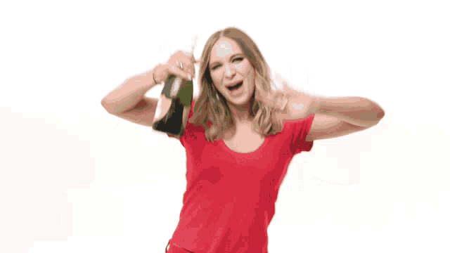 a woman in a red shirt is holding up a bottle of champagne