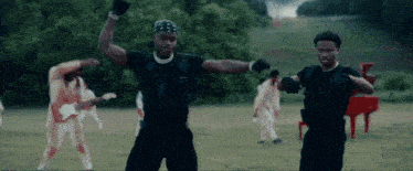 a man in a bandana is dancing in a field with other men