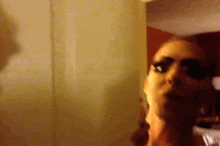 a woman is standing in front of a mirror in a room .